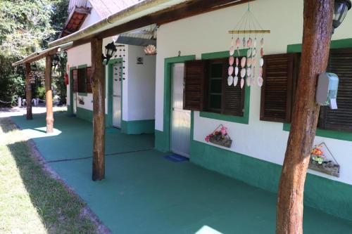 a building with green and white walls and windows at Nosso Chalé na Ilha in Cananéia