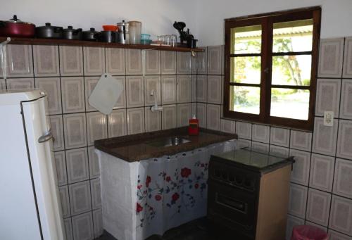 a kitchen with a counter and a sink and a window at Nosso Chalé na Ilha in Cananéia