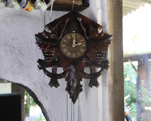 a clock hanging on the side of a wall at Nosso Chalé na Ilha in Cananéia
