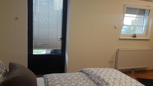 a bedroom with a bed and a window and a door at La Soba in Föhrenhain
