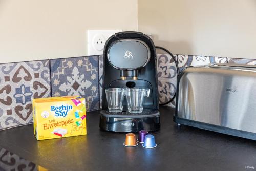a black blender sitting on a counter next to a box at Fontaines de Valence d'Agen Centre Ville Netflix Proche Parking Gratuit in Valence-dʼAgen