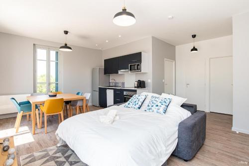 a bedroom with a large bed and a table with chairs at Fontaines de Valence d'Agen Centre Ville Netflix Proche Parking Gratuit in Valence-dʼAgen
