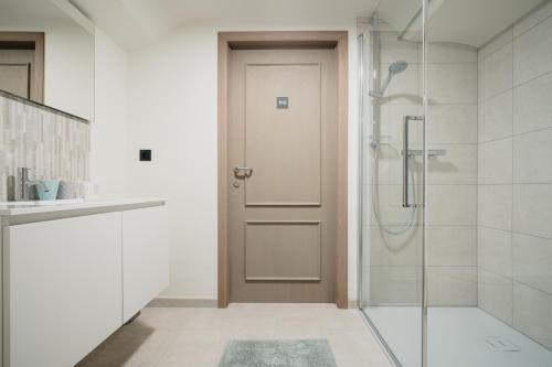 Un baño con ducha y puerta de cristal. en 't Wilgenhuys, en Lommel