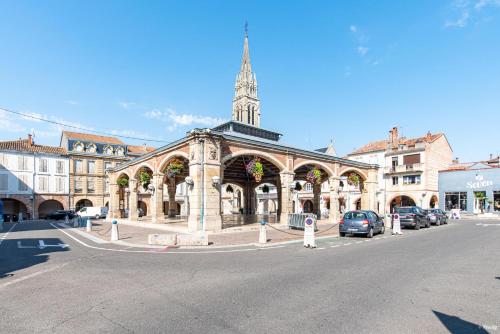 a large building with a clock tower on a street at Fontaines de Valence d'Agen Centre Ville Netflix Proche Parking Gratuit in Valence-dʼAgen