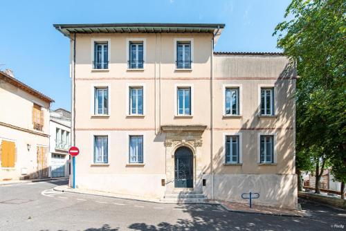 a large white building with a door on a street at Fontaines de Valence d'Agen Centre Ville Netflix Proche Parking Gratuit in Valence-dʼAgen