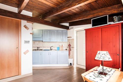 a kitchen with blue and red cabinets and a table at A Casa Di Eta in Gaeta