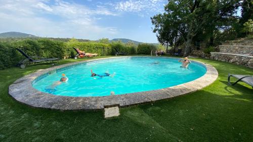 eine Gruppe von Personen, die in einem Schwimmbad schwimmen in der Unterkunft Le Moulin de Varrians in Rians