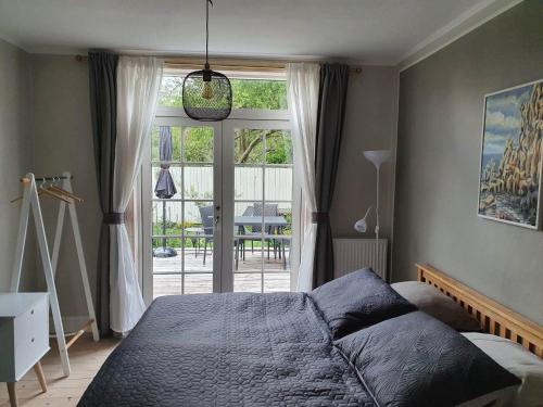 a bedroom with a bed and a large window at BoWell apartments with terrace i Rønne in Rønne