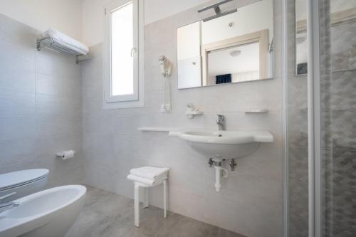 bagno bianco con lavandino e doccia di Hotel Gardenia a Caorle