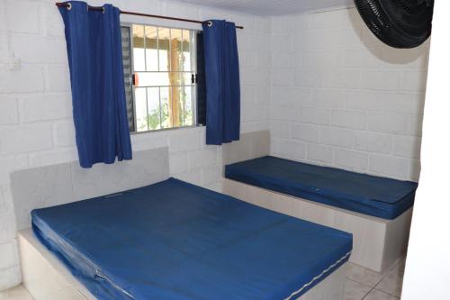 two blue benches in a room with a window at Nosso Chalé na Ilha in Cananéia