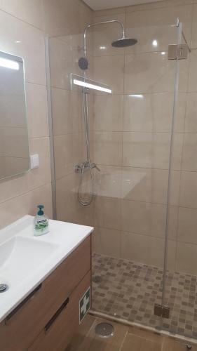 a bathroom with a shower with a sink and a tub at Sunshine Apartment in Quarteira