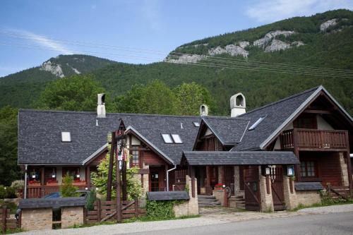 a large wooden house with mountains in the background at Pivovar BUC Kvačany in Kvačany
