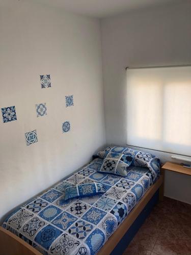 a bedroom with a bed with a blue and white comforter at Caseta del Delta de l'Ebre in Sant Jaume d'Enveja