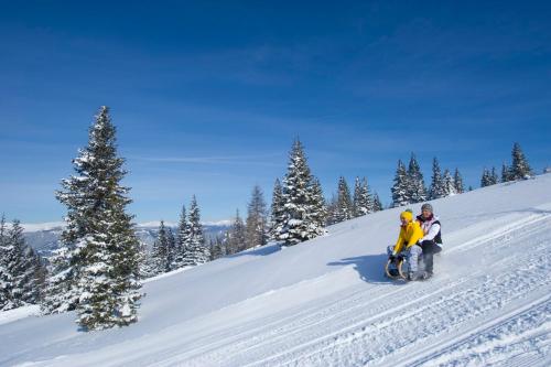 a man and a child on a snow covered slope at Family Home Weißensee in Greifenburg