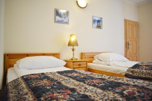 1 dormitorio con 2 camas y lámpara en Willa Pasja, en Zakopane