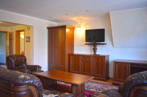 - un salon avec un canapé et une télévision dans l'établissement Willa Pasja, à Zakopane