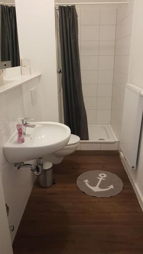 a bathroom with a sink and a toilet and a shower at Flensburg City - 24h in Flensburg