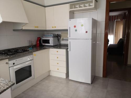 cocina con electrodomésticos blancos y nevera blanca en Apartamento la luna, en Castellón de la Plana