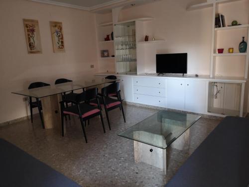sala de estar con mesa, sillas y TV en Apartamento la luna en Castellón de la Plana
