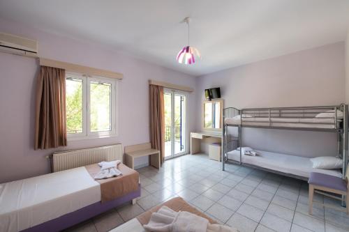 a bedroom with two bunk beds and a bathroom at Surf Hotel in Vasiliki