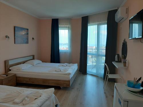 a hotel room with two beds and a balcony at La MER 2 in Tsarevo