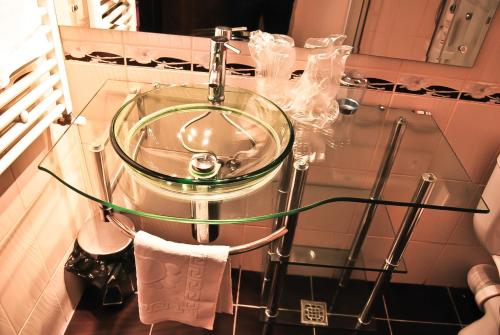 a glass sink in a bathroom with a towel at Hotel Magic GT Trivale in Piteşti