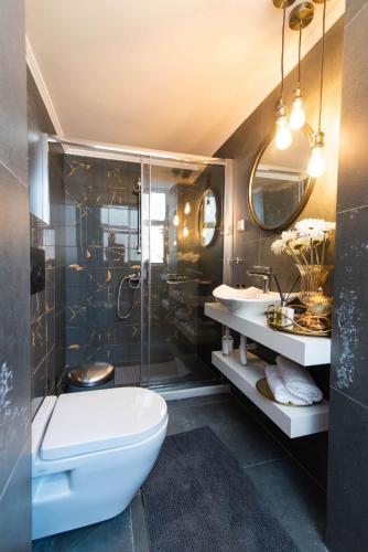 a bathroom with a toilet and two sinks and a shower at Cozy and Style in Preveza