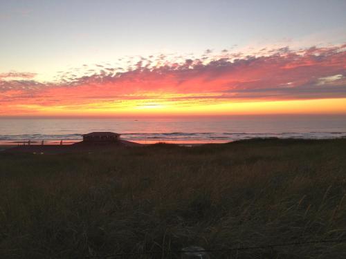 a sunset on the beach with the ocean at Villa 't Haasduin in Wijk aan Zee