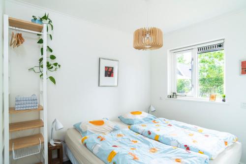 オッテルローにあるVakantiehuisje Spechtのベッドと窓のある白い寝室