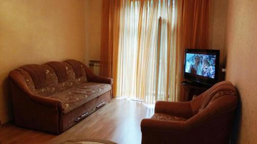 a living room with a couch and a television at Комната в двухкомнатной in Kyiv