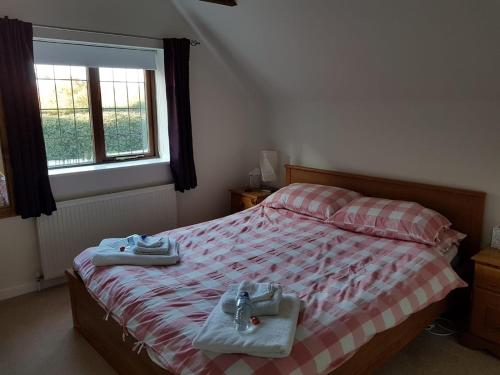 a bedroom with a bed with two towels on it at Binfield Annexe in Bracknell