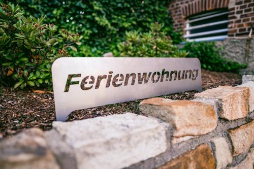 a sign for a garden on a brick wall at Klärchen's Stube in Telgte