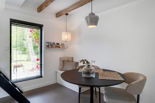 a dining room with a table and chairs and a window at The Slow in Zuidoostbeemster
