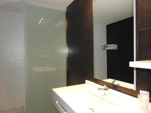 a bathroom with a sink and a mirror at Hostal Meson de Paco in Cariñena
