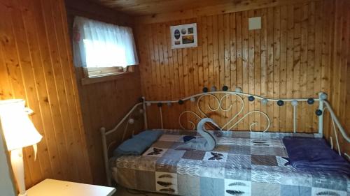 a bedroom with a bed with a quilt on it at Polar Cottage House Bodø in Nygårdsjøen