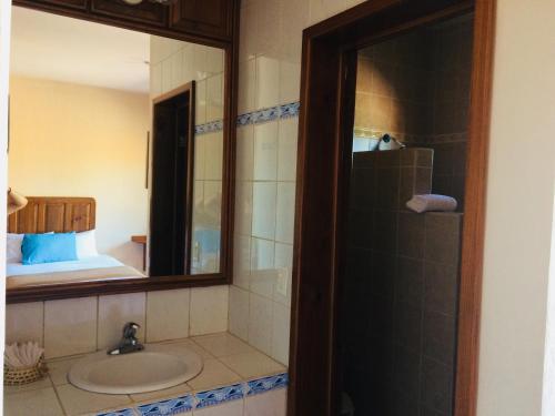 a bathroom with a sink and a mirror at Hotel Angra in Loreto