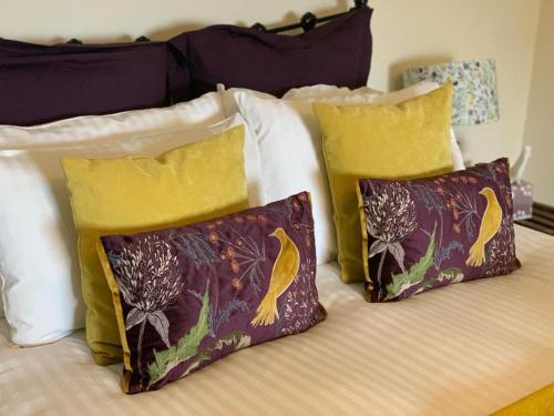 a bed with four pillows on it with at Low Gingerfield Farm B&B in Richmond