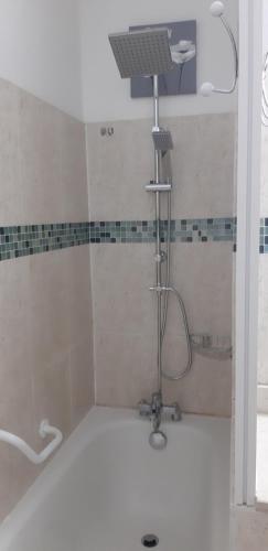 y baño con ducha y bañera. en Studio entre ciel et mer sans coupure d'eau, en Le Gosier