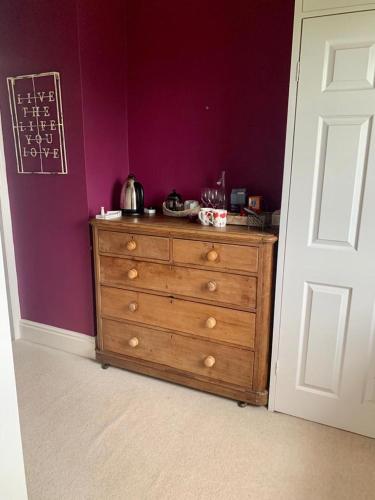 a wooden dresser in a room with a purple wall at Low Gingerfield Farm B&B in Richmond