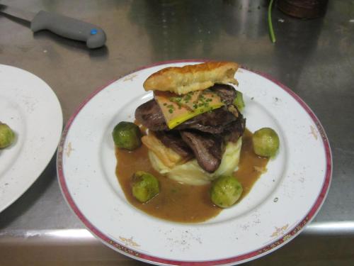 a plate of food with a sandwich and potatoes at LOGIS-Hôtel Restaurant Auberge Les Vallées Du Perche in Vichères