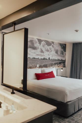 a hotel room with a bed and a large painting on the wall at Vinland Hotel and Lounge in Solvang