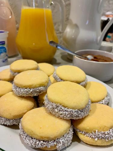 a plate of cookies on a table with orange juice at Hotel FK Paso de los Toros - Hotel Boutique in Santa Isabel