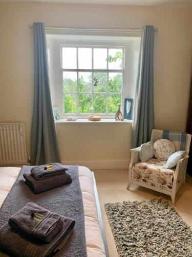a bedroom with a bed and a window and a chair at Low Gingerfield Farm B&B in Richmond