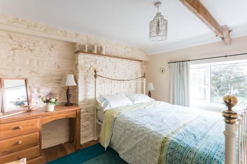 a bedroom with a bed and a stone wall at 2 Tan Yr Eglwys in Pontardawe