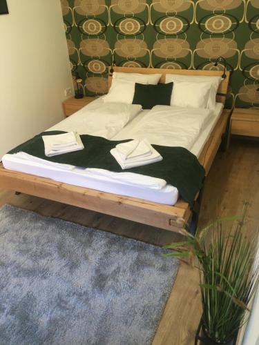 a bed with white sheets and pillows in a bedroom at Boróka Apartman Belváros in Veszprém