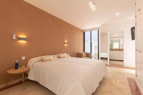a bedroom with a large white bed and a table at Villa Sea Breeze Callao in Playa Blanca