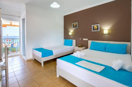 a hotel room with two beds and a balcony at Green Velvet Thassos in Pefkari