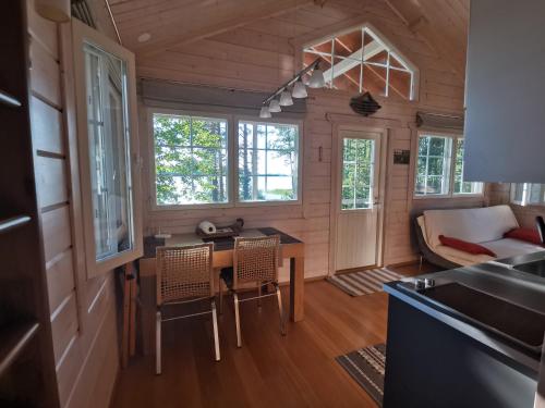 une cuisine et un salon avec une table et des chaises dans l'établissement Vuori Camp by Saimaa, à Vuoriniemi