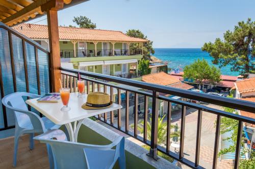 a balcony with a table and chairs and the ocean at Green Velvet Thassos in Pefkari
