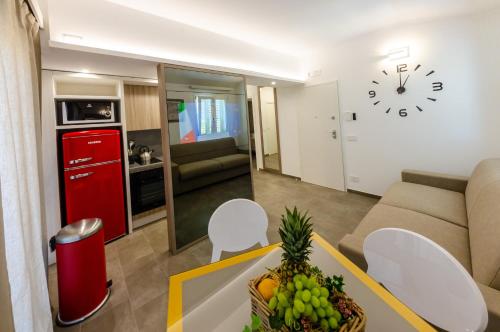 ein Wohnzimmer mit einem Sofa und einer Uhr an der Wand in der Unterkunft Calanica Boutique Apartments in Cefalú